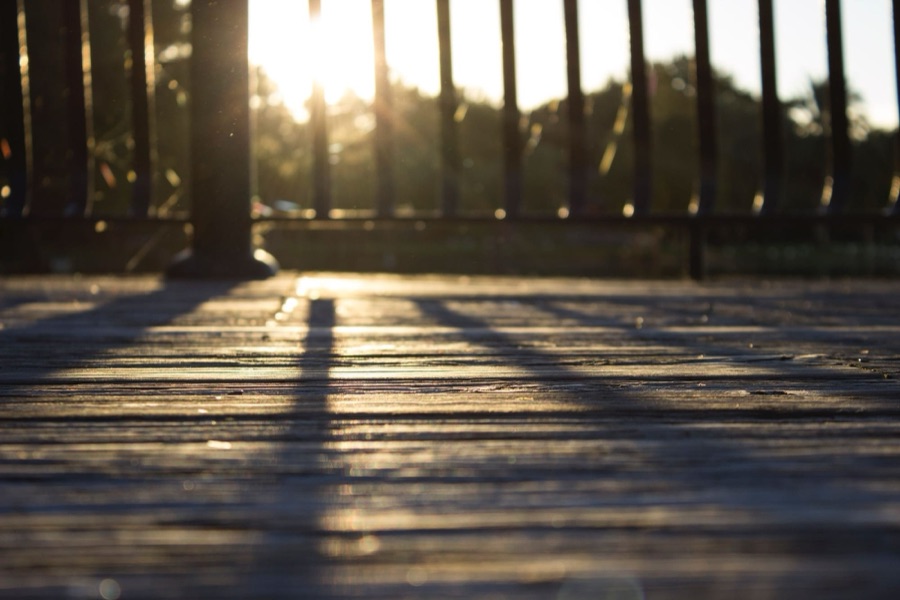 Sunlight across a wood deck and railing